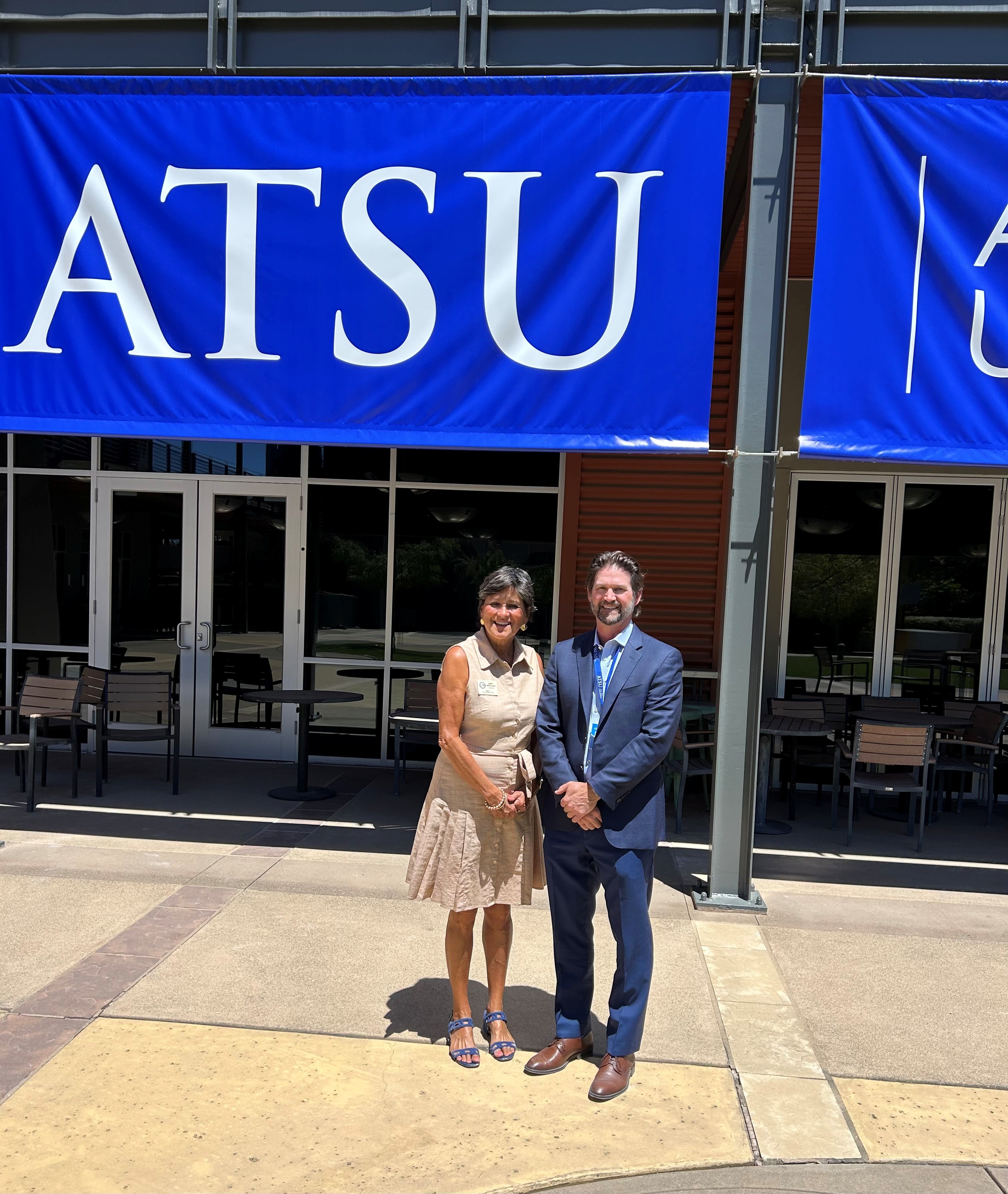 Supervisor Ortiz-Legg and ATSU Dean in front of ATSU sign
