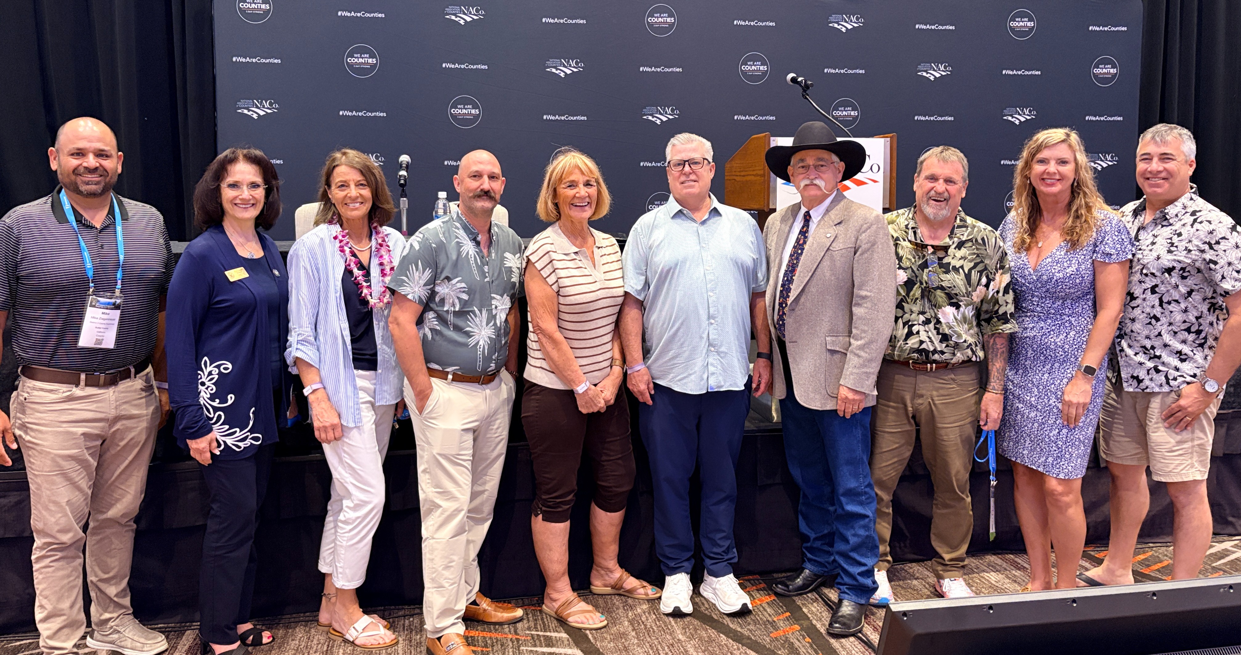 Supervisor Suzanne Jones standing on a stage with other California County Supervisors at the NACO conference.