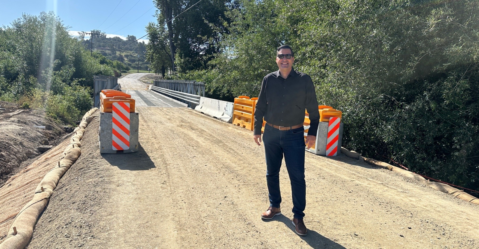 Supervisor Paulding standing in front of the newly installed temporary bridge at Cecchetti Road