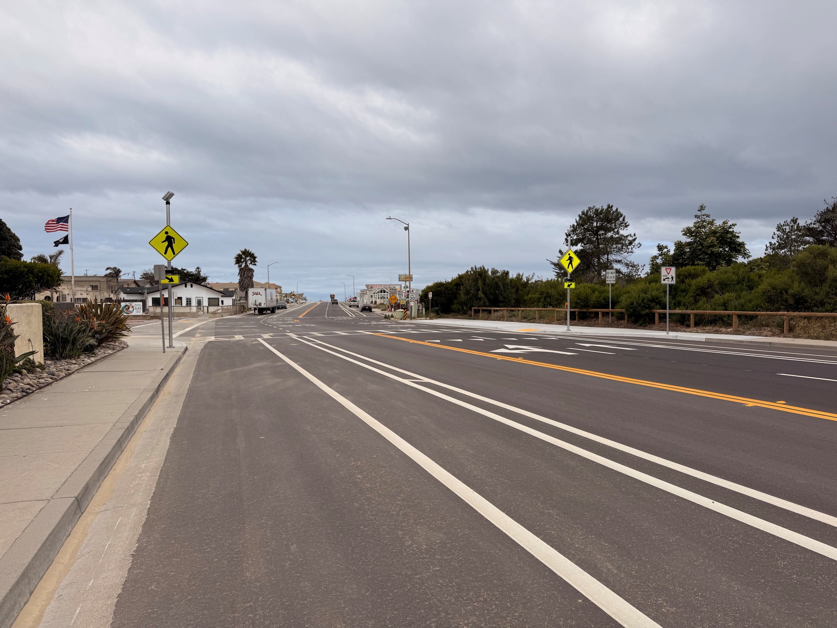 Pier Ave with new pavement, bike lanes, and rapid flashing beacon crosswalks